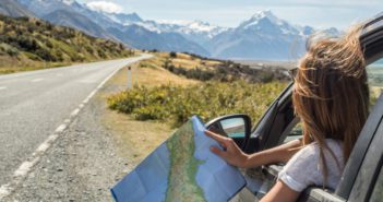 Portrait of young woman in car looking at map © swissmediavision/GettyImages