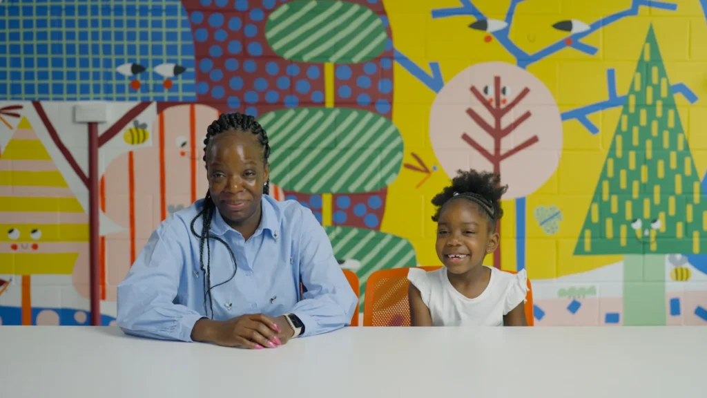 Adult and young child sitting at a table on the set of The Secret Life of 5 Year Olds